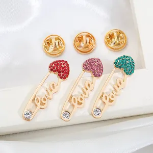 Drei elegante Herz-Sicherheitsnadel-Broschen mit Love-Schriftzug und bunten Kristallen.