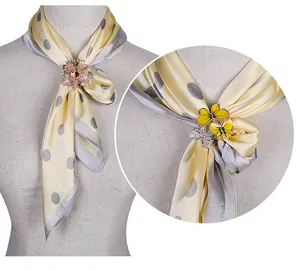 Detailansicht der eleganten Blumen- und Schmetterlings-Strass-Schalringe auf einem Schal