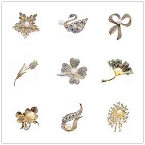 Elegantes Set mit 9 goldfarbenen Perlen- und Strassbroschen in Blumen- und Schwanendesign