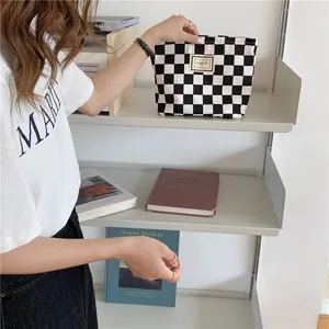 Black and white checkered canvas pouch placed on a modern minimalist shelf for decor