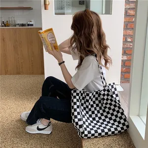 Detail shot of a large black and white checkerboard canvas tote bag in a cafe setting