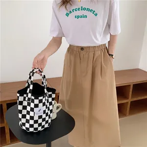 Close-up of a chic black and white checkerboard canvas handbag in a minimalist setting