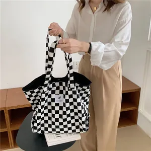 Detailed view of large black and white checkerboard canvas tote bag with chic aesthetic