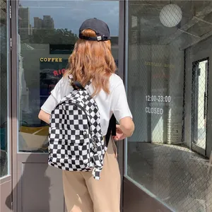 Lifestyle view of a stylish black and white checkered canvas backpack for students