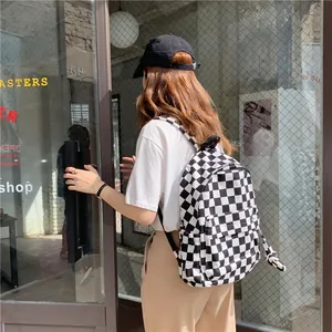 Classic black and white checkered canvas backpack for women shown in a street scene