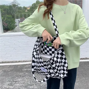 Detailed view of checkerboard canvas tote bag on model, highlighting large capacity design.