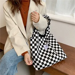 Close-up detail of a stylish black and white checkered canvas tote bag for women