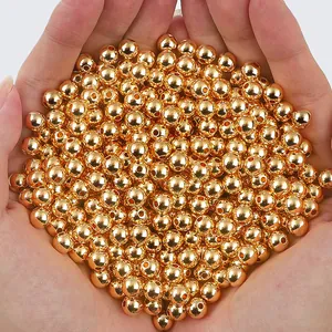 Macro view of polished 14K gold-filled smooth round spacer beads for DIY jewelry