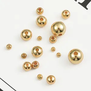 Close-up of various sized 14K gold-filled smooth round spacer beads for jewelry DIY.