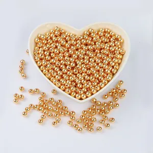Close-up of 14K gold-filled smooth round beads in a heart-shaped dish for DIY jewelry