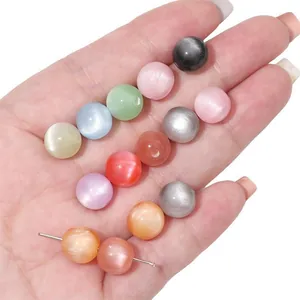 Macro view of colorful resin imitation cat eye beads held in hand for DIY jewelry