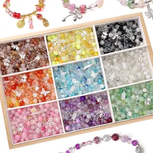 Close-up detail of colorful mixed glass beads and silver alloy charms in wooden box