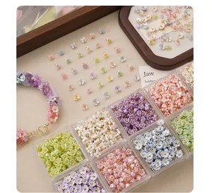 Macro view of colorful resin flower charms in clear storage organizer for jewelry