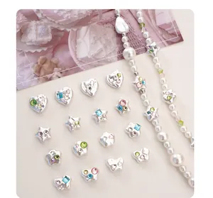 Gros plan de divers charms en perles Mabe en acrylique argenté avec strass colorés