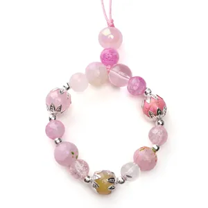 Detailed view of handmade pink glass bead bracelet with silver alloy flower caps and spacers.