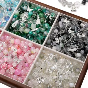 Close-up of mixed glass beads and alloy charms in a wooden organizer box