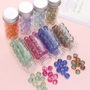 Vue détaillée de perles en verre facettées de 10mm en flacons sur fond rose