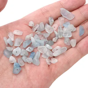Perles en verre concassé bleu clair irrégulières pour bijoux DIY présentées sur paume