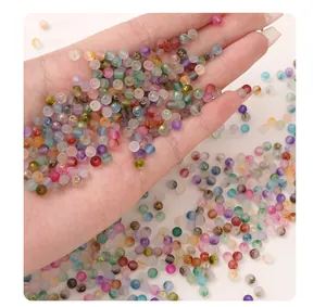 Hand holding various 7mm frosted phantom glass beads for DIY jewelry making.