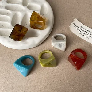 Close-up detail of faceted resin rings featuring vintage marbled patterns in various colors
