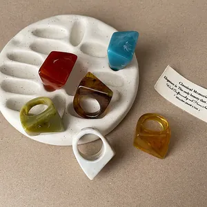 Close-up of geometric marble pattern resin rings on a textured display tray