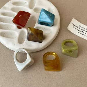 Detailed view of faceted resin rings with marbled swirl patterns in multiple colors