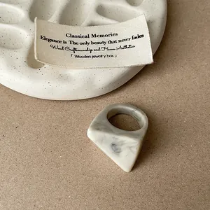 Macro shot of a geometric resin ring with a grey marble swirl and faceted texture