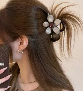 Primo piano di una pinza per capelli a fiore marrone marmorizzato per acconciatura
