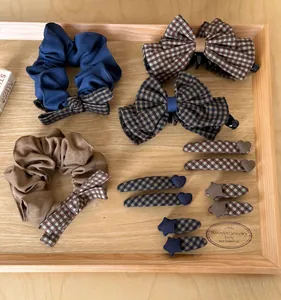 Assortment of retro checkered hair clips and scrunchies presented on a wooden tray