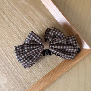 Macro view showing the texture of the brown checkered bow on a hair banana clip