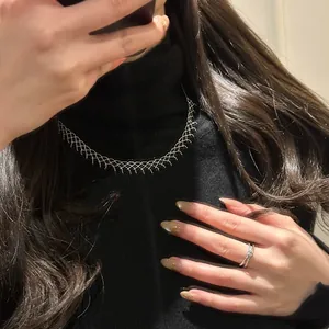 Detailed view of elegant mesh lace silver choker necklace worn by model in black sweater