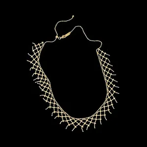 Detailed macro view of a golden mesh lace necklace with delicate bead design.