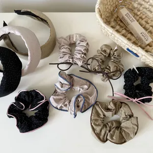 Detailed view of polka dot scrunchies and fabric headbands in elegant earthy tones.