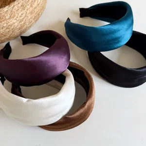 Macro shot of assorted satin padded wide headbands in various colors showing silky texture