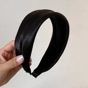 Close-up detail of wide black satin padded headband for elegant French style hair