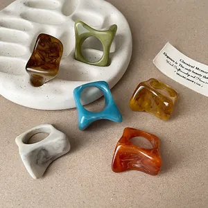 Collection artistique de bagues en résine colorées irrégulières à motifs marbrés.
