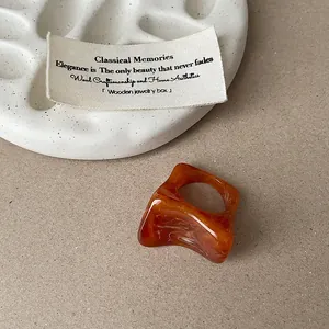 Vue détaillée montrant la texture unique d'une bague en résine ambrée marbrée