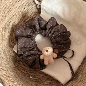 Gros plan d'un chouchou marron à pois avec un mignon petit ours en peluche