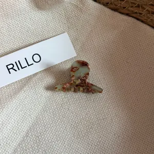 Close-up of mini French acetate hair claw clip with chocolate marble pattern texture.