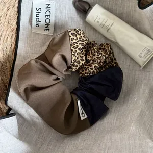 Close-up of leopard print and solid brown fabric textures on a large hair scrunchie.