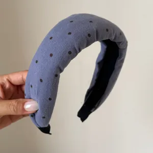 Primo piano del cerchietto imbottito retrò blu a pois dal design spesso