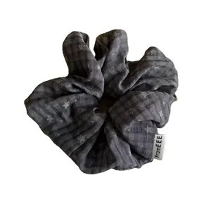 Soft dark gray fabric scrunchie with star and grid pattern for stylish bun hairstyles