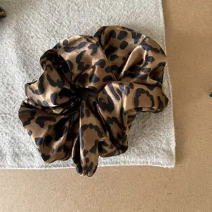 Close-up detail of a vintage leopard print scrunchie with silky satin fabric texture