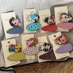 Detail showing seven cartoon girl hair clips with patterned acetate oval bases