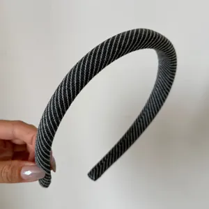 Dettaglio del cerchietto imbottito a righe twill grigie e bianche per donne eleganti