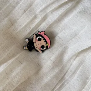 Detailed macro shot of a cute retro cartoon girl character charm with a pink headband