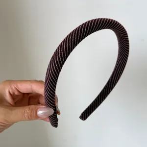 Primo piano di un cerchietto a righe diagonali marrone scuro con trama fine