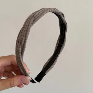 Detailed close-up of a brown plaid twist headband with textured fabric