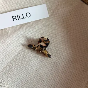 Detailed macro view of a mini tortoise shell acetate hair claw clip in chocolate tones