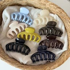Elegant assorted large dragon bone hair claw clips presented in a natural woven basket
